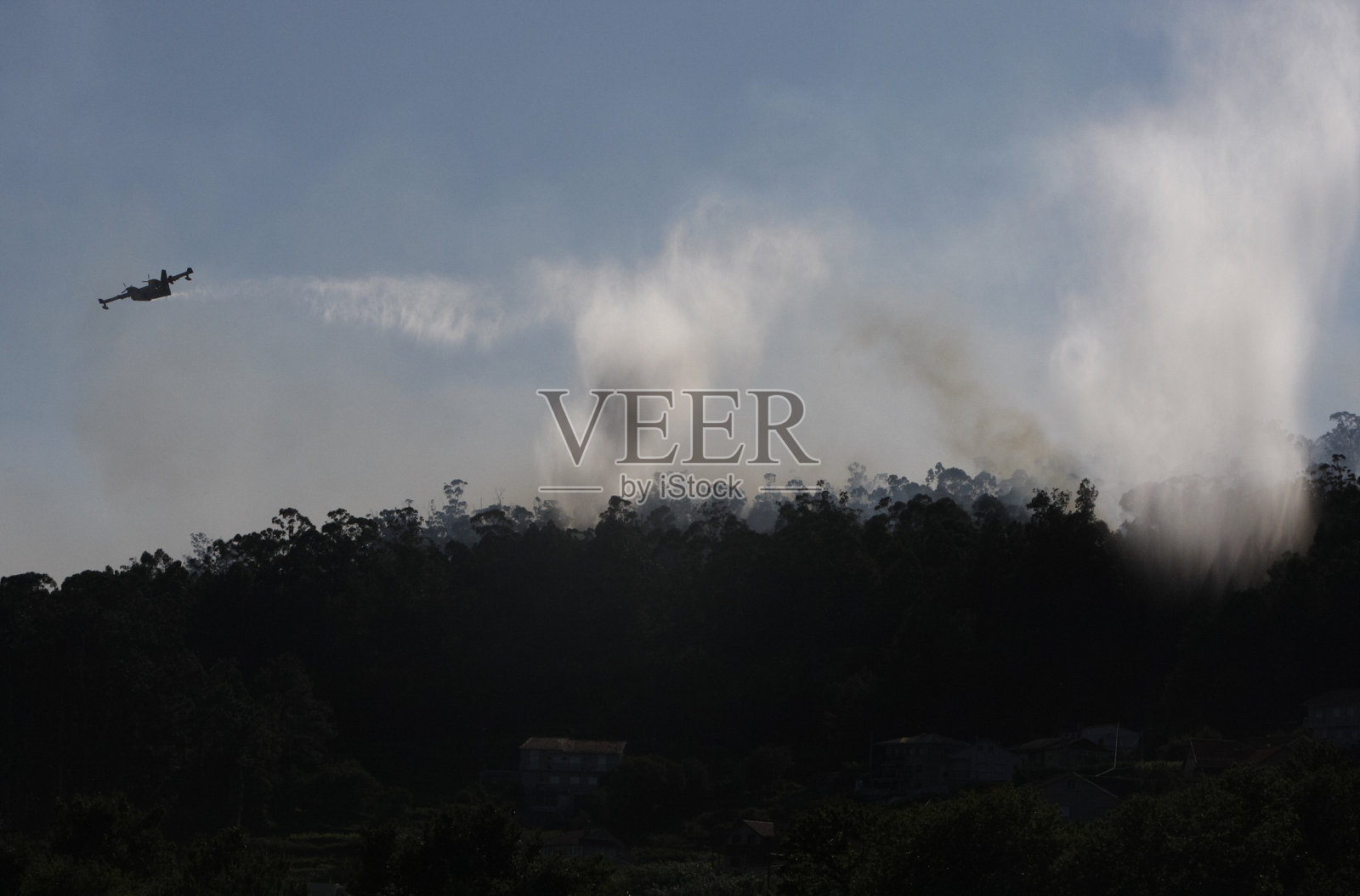 一架Canadair CL-215消防飞机在森林大火的云雾中照片摄影图片