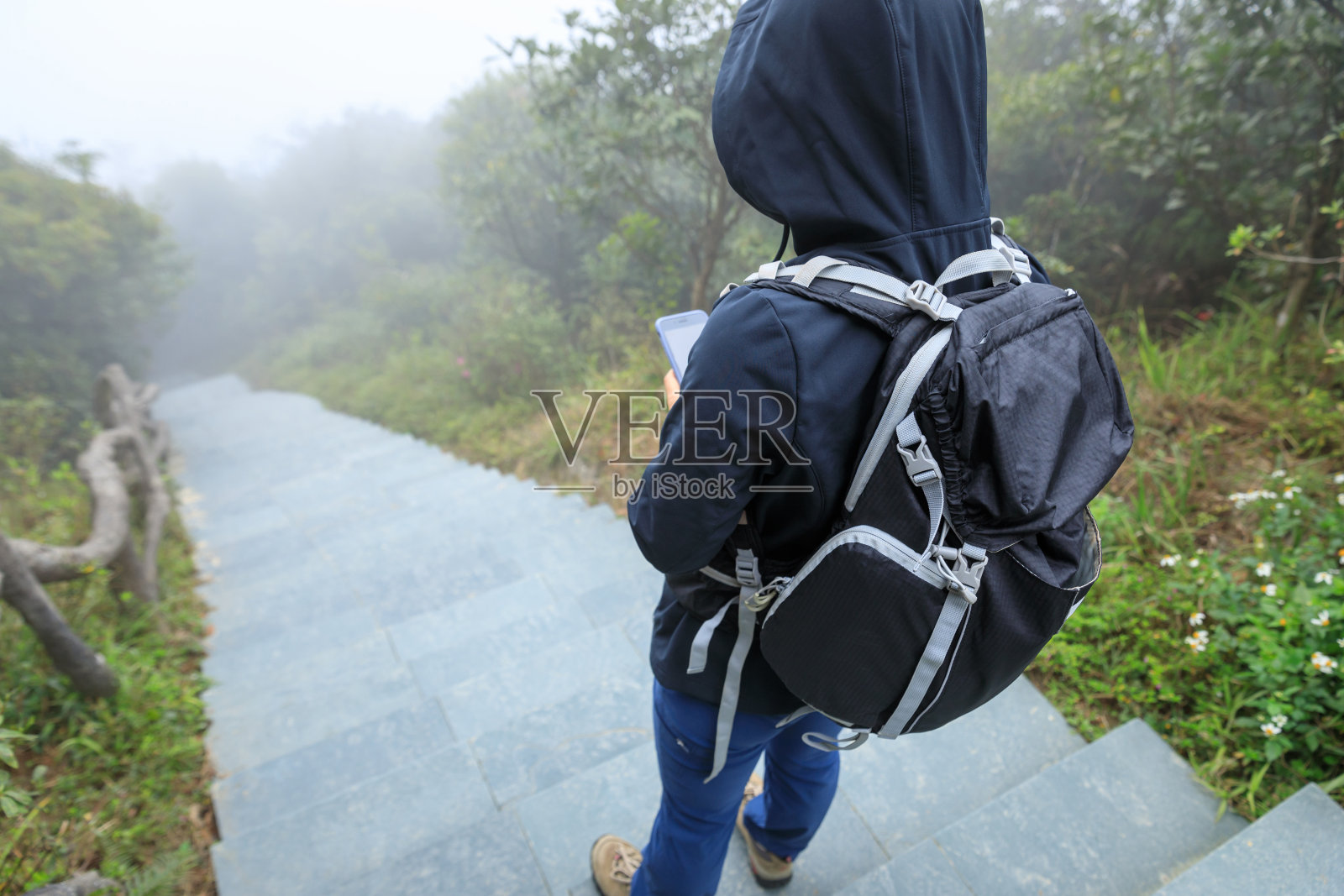 登山者在雾蒙蒙的山顶使用智能手机照片摄影图片