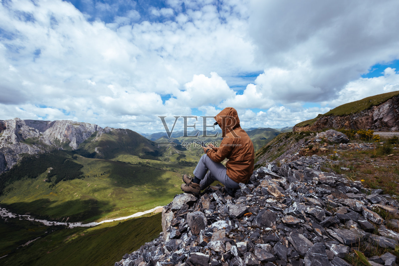 成功的女徒步旅行者在高山山顶使用智能手机照片摄影图片