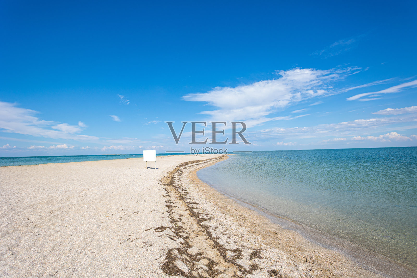 迷人的海滩，无边无际的地平线。柔软的波浪在沙滩上的蓝色海洋。背景。照片摄影图片