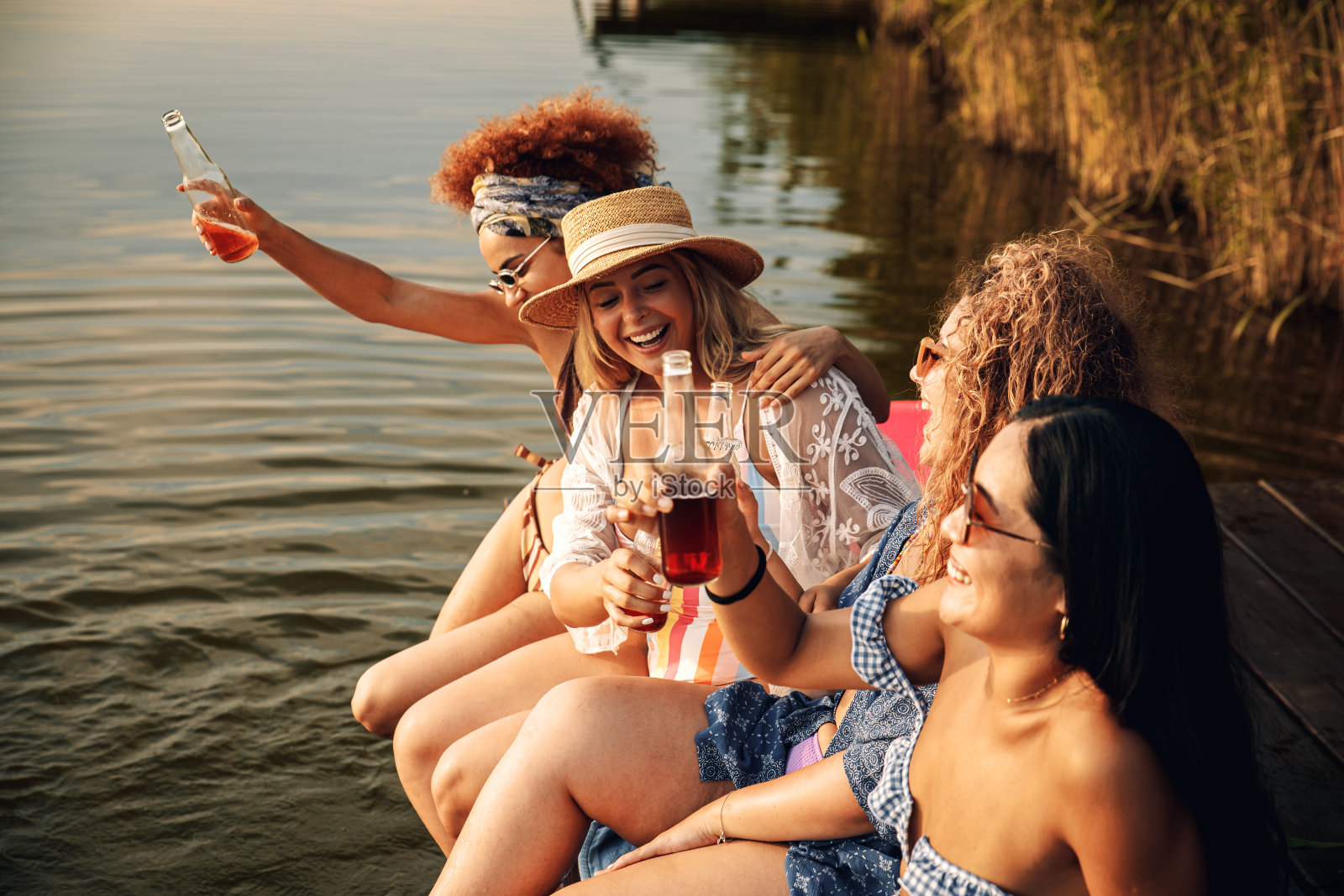 一群女性朋友在湖边享受夏日时光。照片摄影图片
