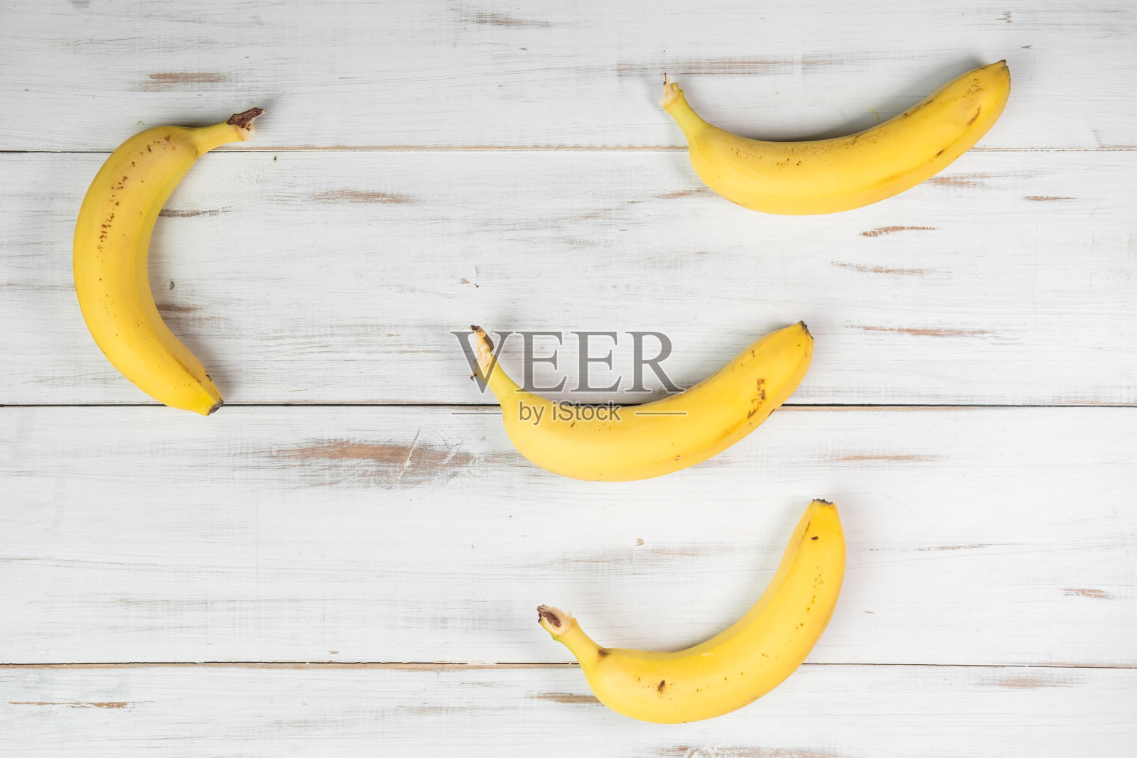 木制背景上的几根香蕉。普通的带斑点的香蕉。照片摄影图片