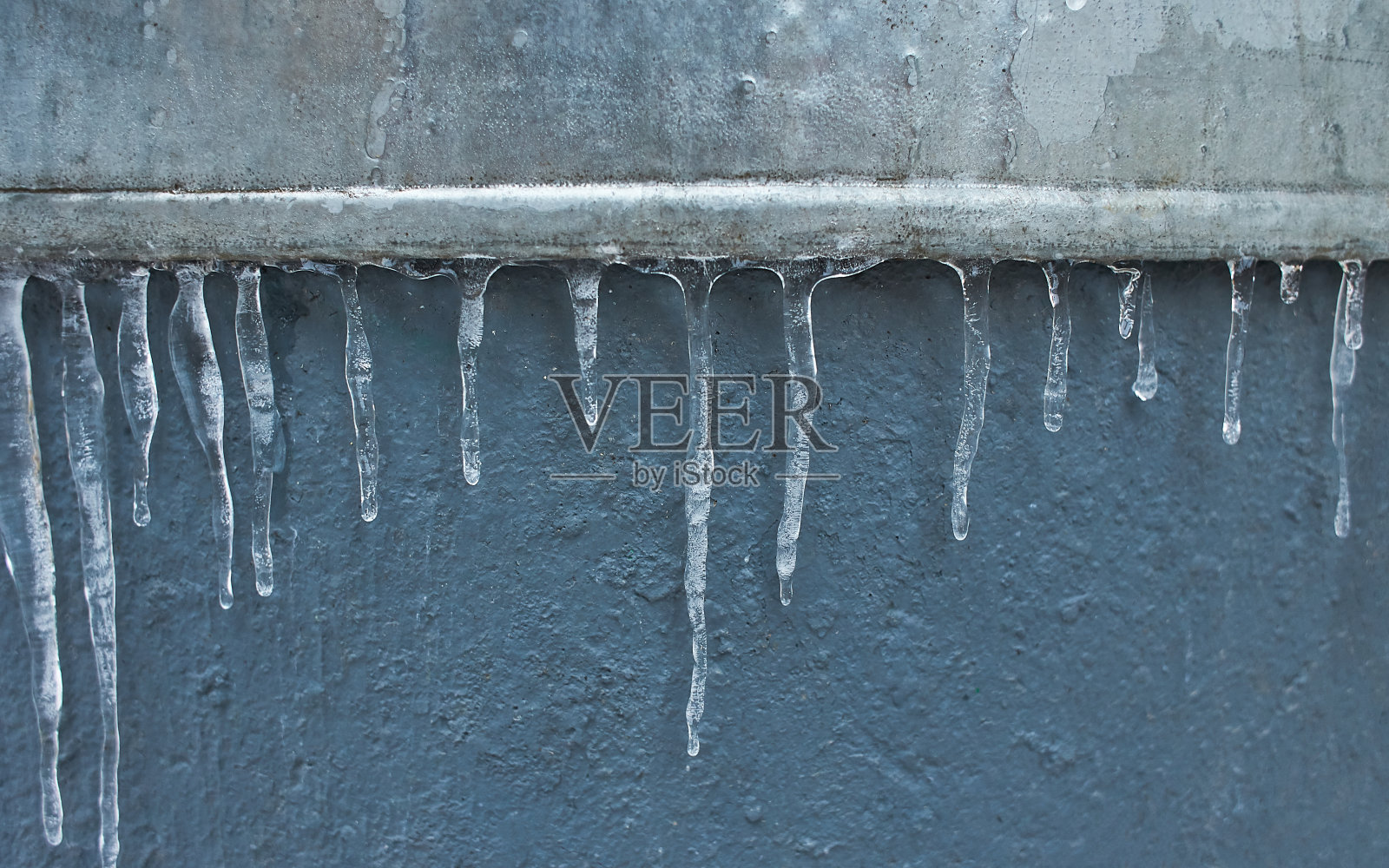 冰柱垂下，滴落。冬天到春天。浅景深。冰晶图案，悬挂联合国和平的木材。照片摄影图片