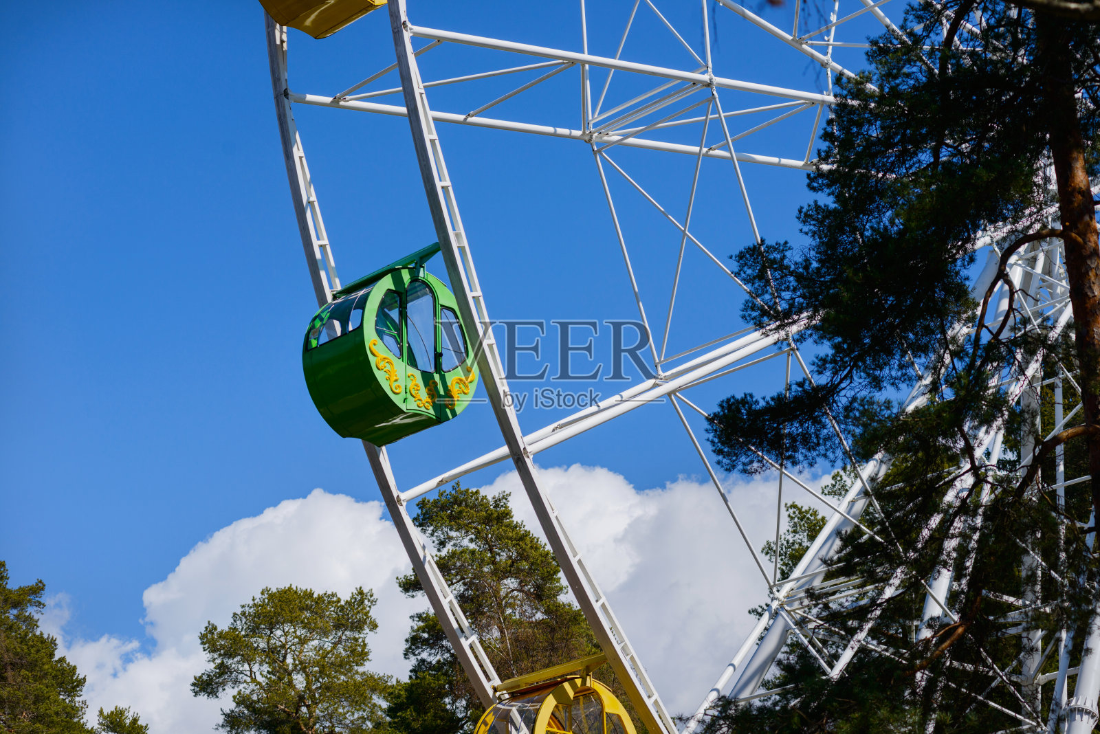 公园里的摩天轮。摩天轮上空空如也的座舱，映衬着湛蓝无云的天空。照片摄影图片