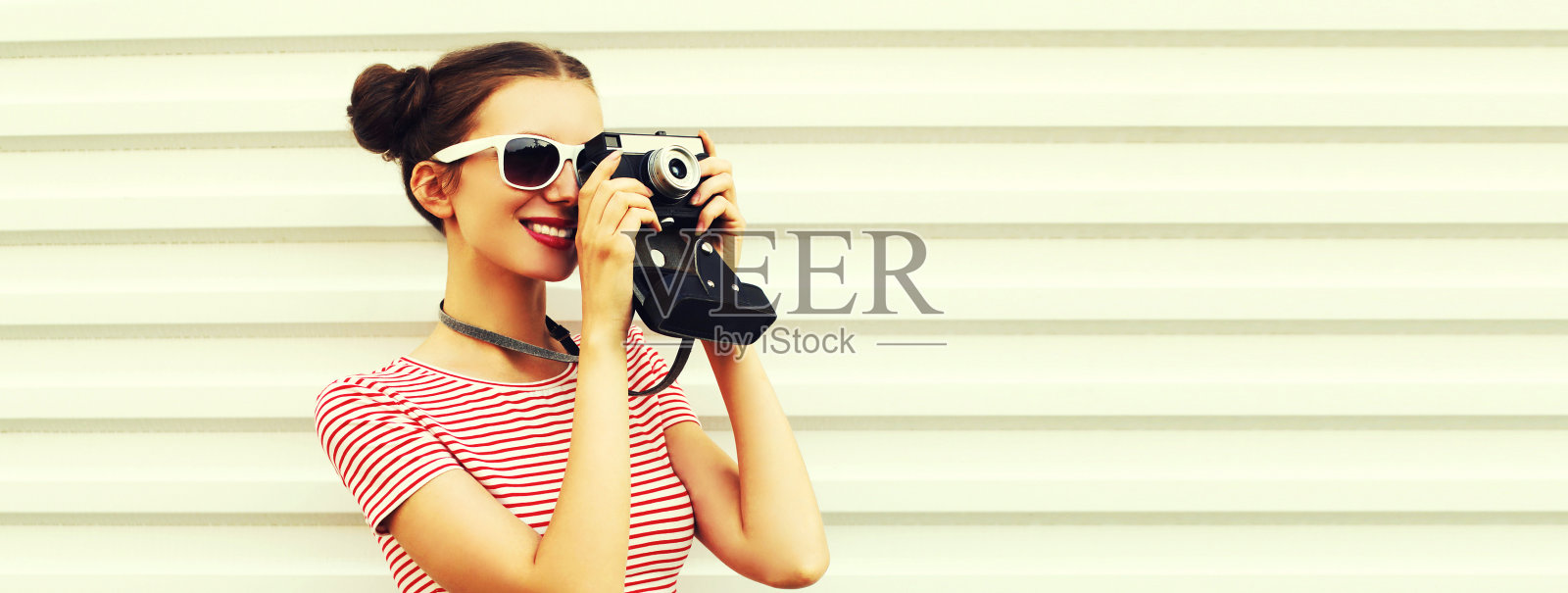 快乐微笑的年轻女性摄影师与老式胶卷相机的肖像，在白色的背景下凉爽的少女发型的女性照片摄影图片