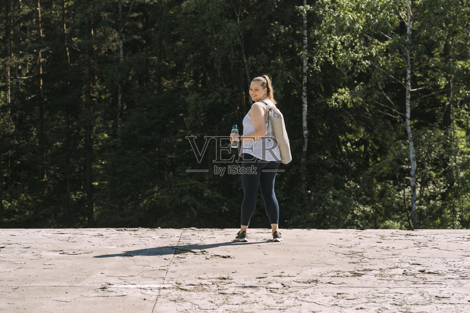 一个快乐的白人女性在做瑜伽后从瓶子里喝水照片摄影图片