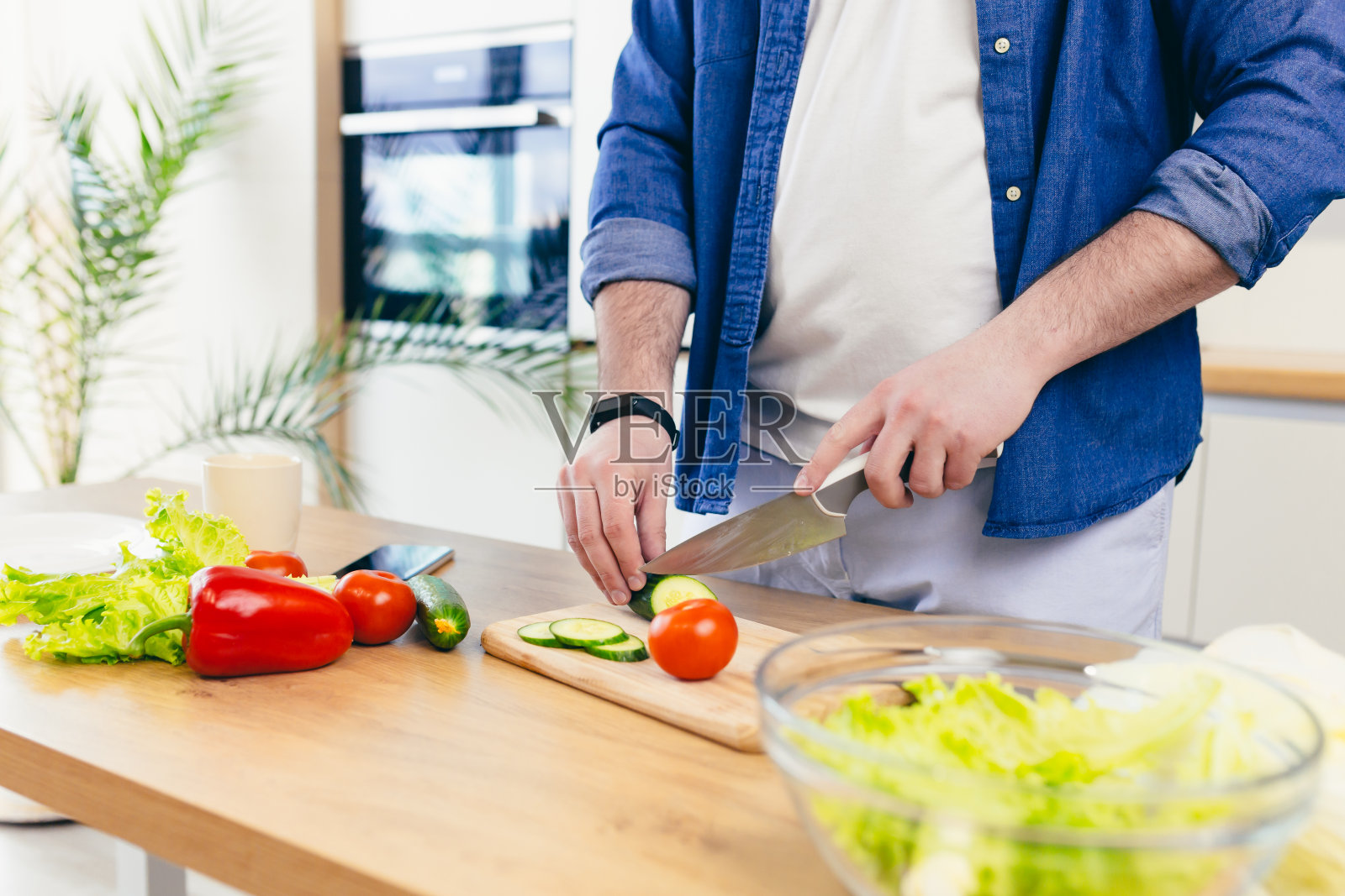 特写镜头，年轻人在家里的厨房里准备新鲜的蔬菜和水果，健康的食物照片摄影图片
