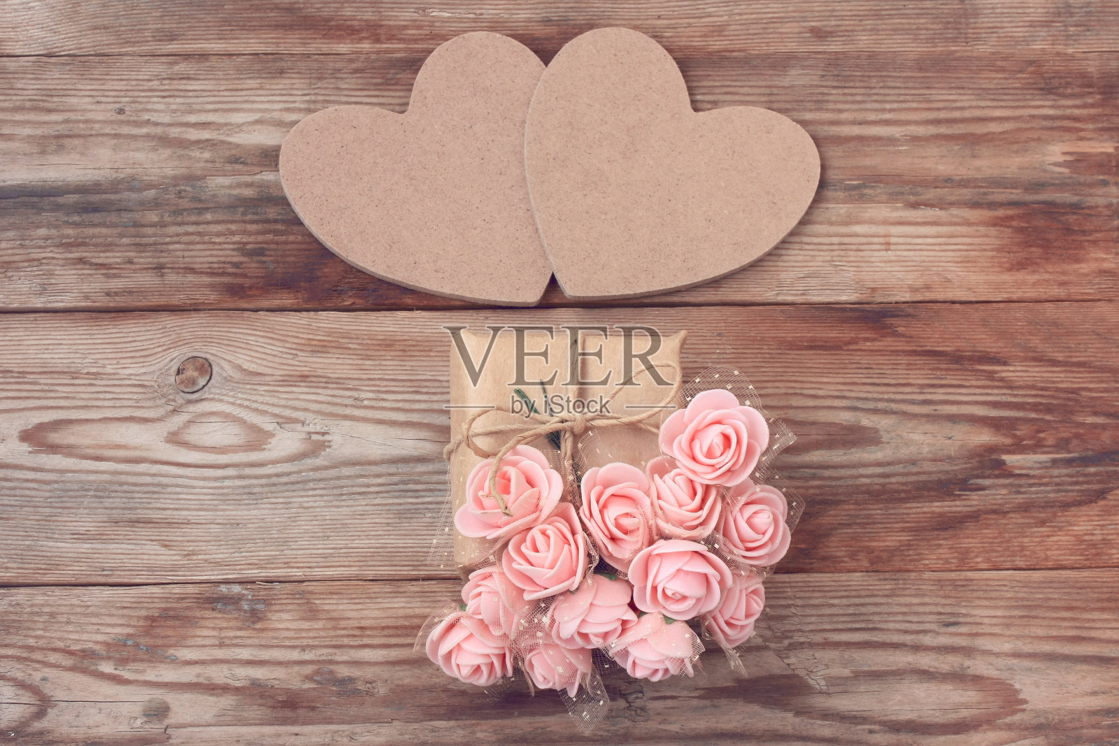 两个硬纸板心，牛皮纸包裹的礼盒，一束粉红色的玫瑰照片摄影图片