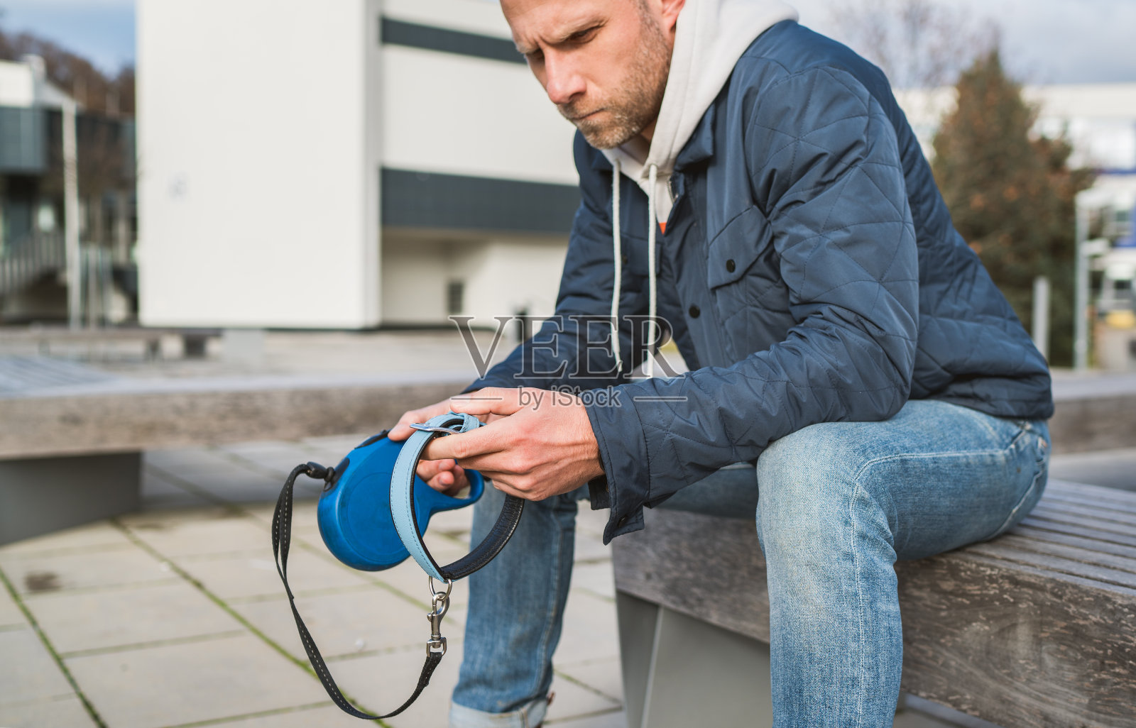 悲伤的男人和狗主人坐在长椅上，拿着宠物项圈，为失去动物而深感悲痛，家庭宠物亲属和爱概念照片摄影图片