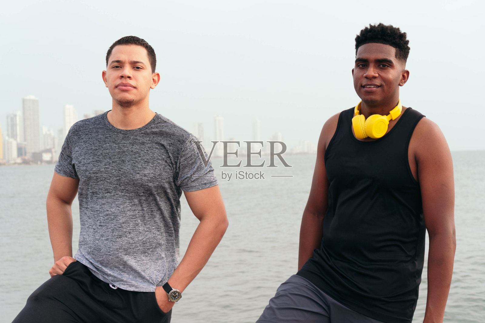 两个健康的年轻男子在户外有氧运动训练后放松的肖像。照片摄影图片