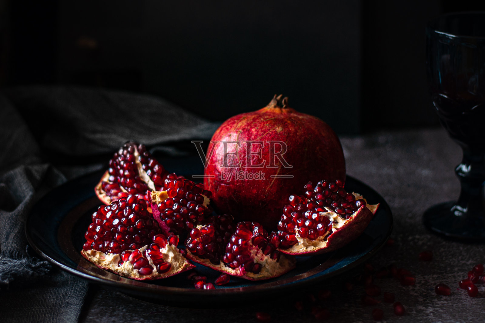 石榴放在深色的桌子上。红的，熟的，甜的，好吃的照片摄影图片