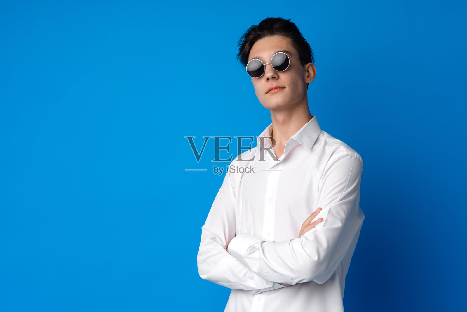 一个微笑的少年在蓝色背景下的肖像照片摄影图片