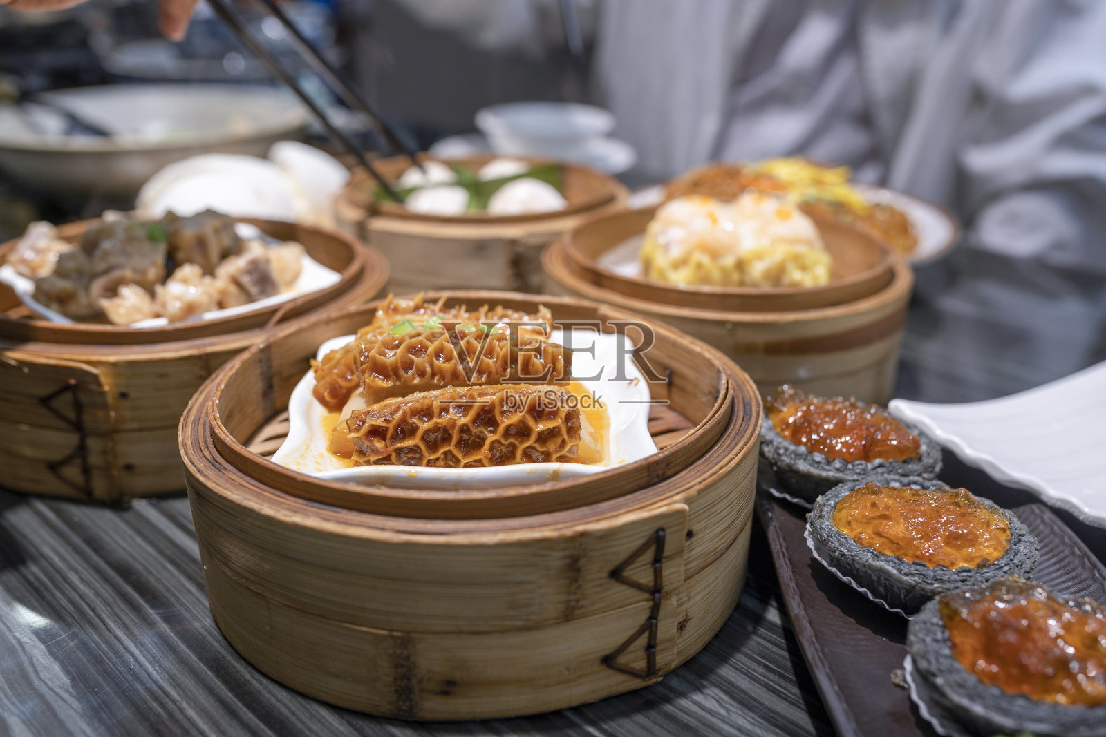 餐馆里用筷子吃广东dum sum的人照片摄影图片