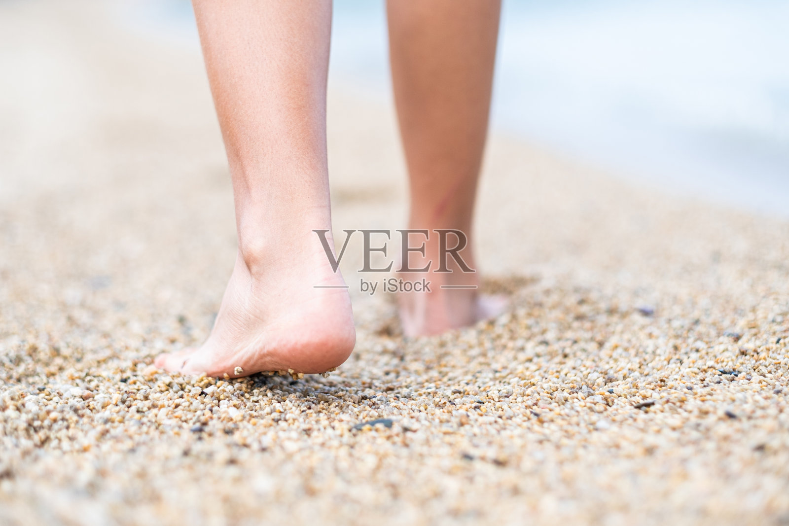 在沙滩上的鹅卵石上散步。照片摄影图片