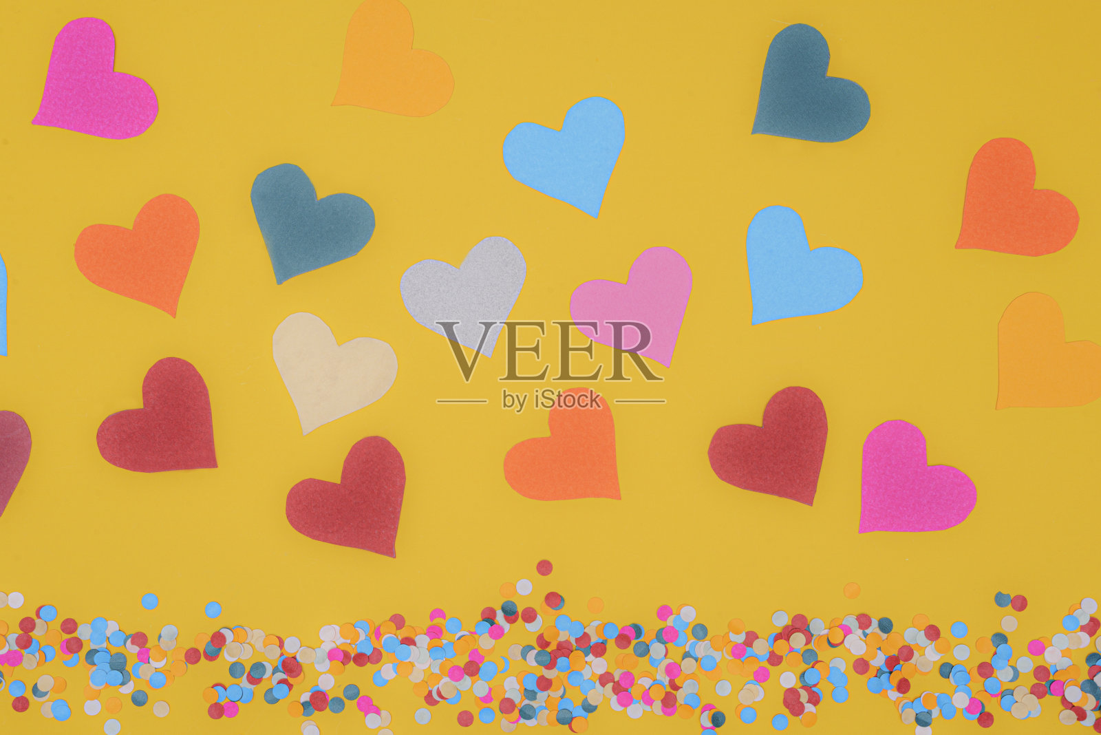 彩色心形纸在黄色背景与五彩纸屑照片摄影图片