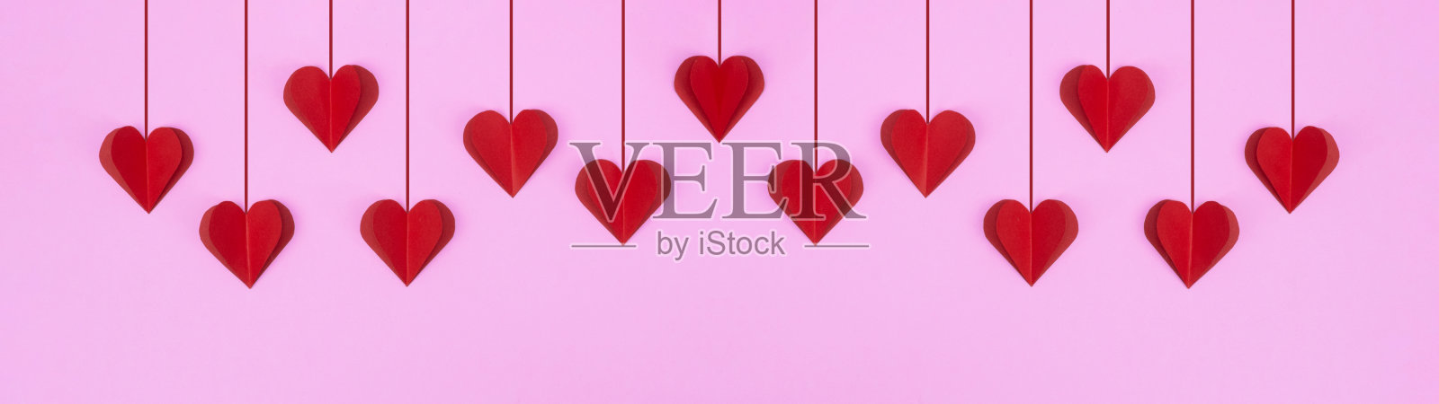 情人节快乐的背景横幅全景贺卡模板-红色挂心孤立在粉红色的纸纹理照片摄影图片