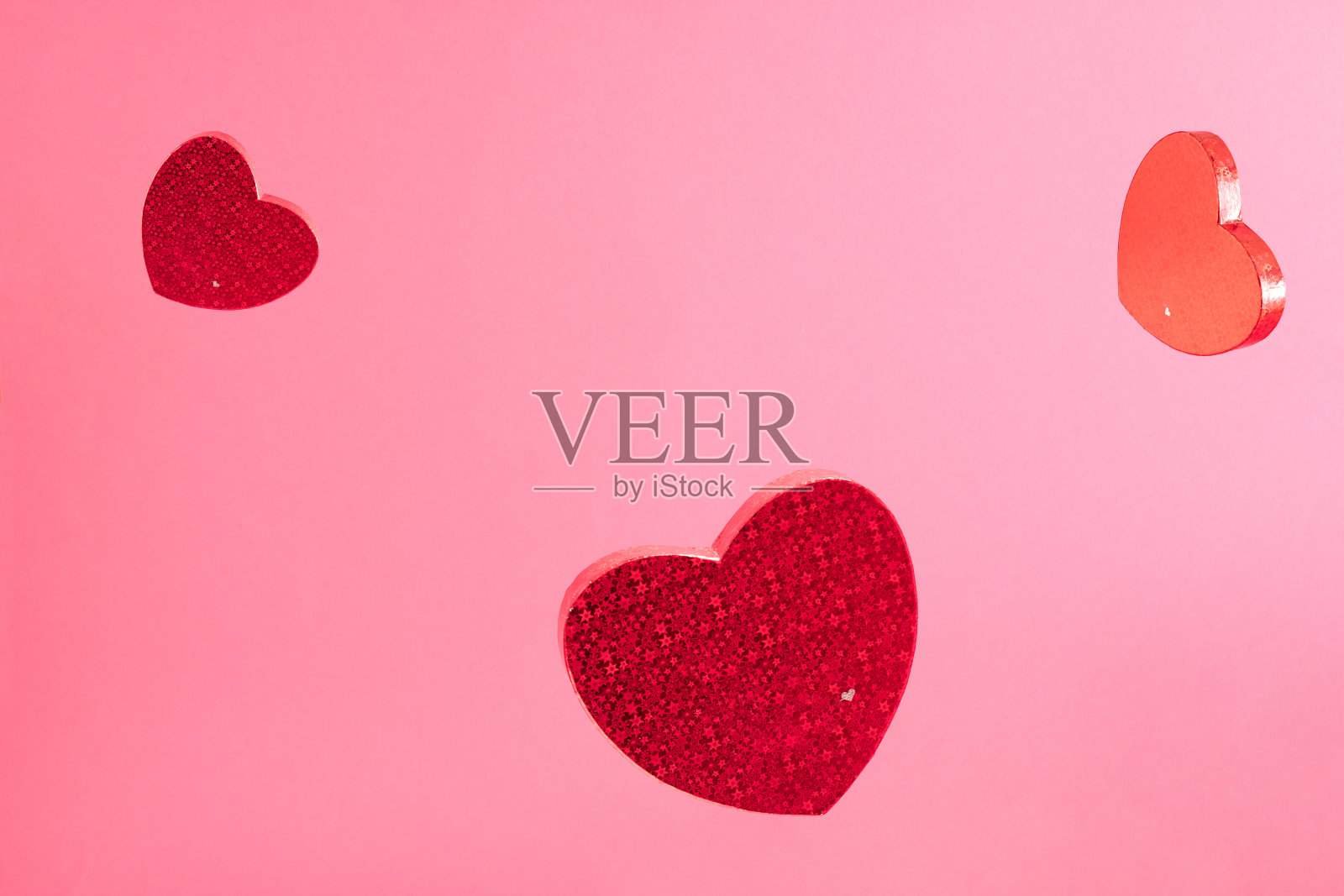 三颗红心在洋红色背景的空中。爱创意概念。情人节的最小构成。照片摄影图片