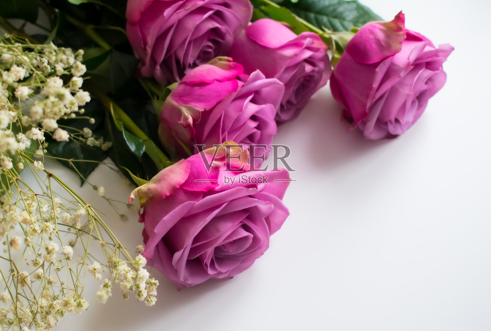 桌上的鲜艳粉色玫瑰花束照片摄影图片