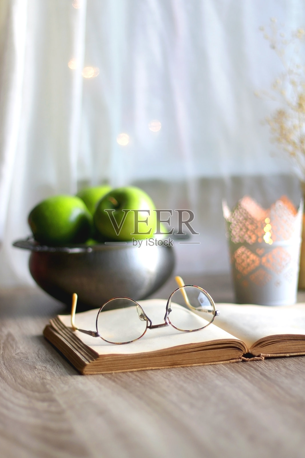 绿苹果，书和蜡烛照片摄影图片