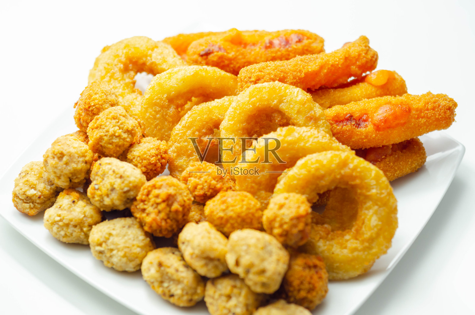 白色盘子上盛着南方炸烤鸡块、洋葱圈和马苏里拉奶酪条照片摄影图片