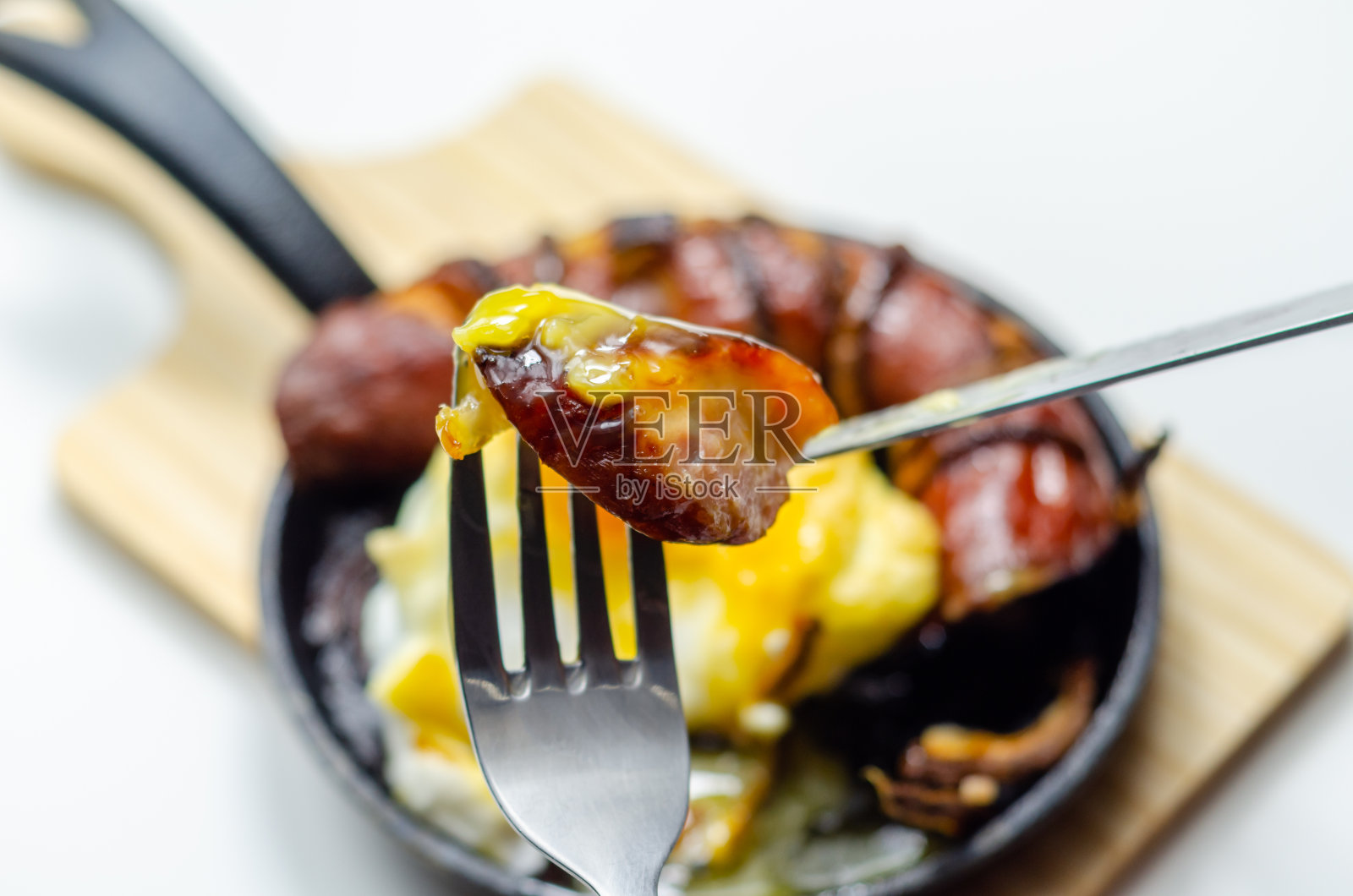 在云中吃着烤香肠、洋葱和鸡蛋，都是用铸铁锅盛着的照片摄影图片