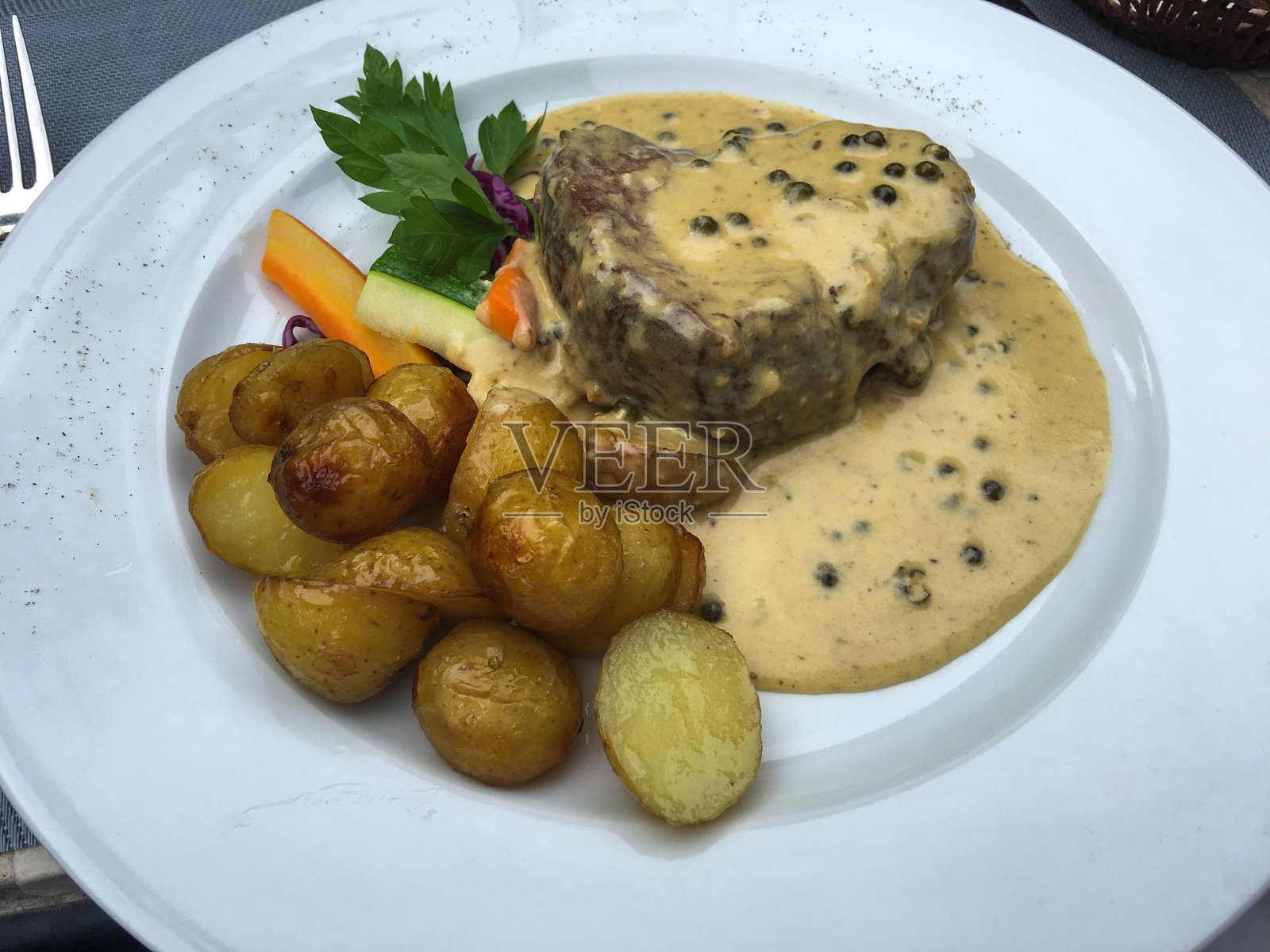 白盘子上的牛排配辣椒酱和炸土豆照片摄影图片