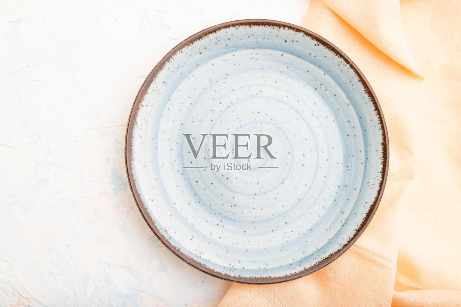 空蓝色陶瓷板在白色混凝土背景。前视图。照片摄影图片