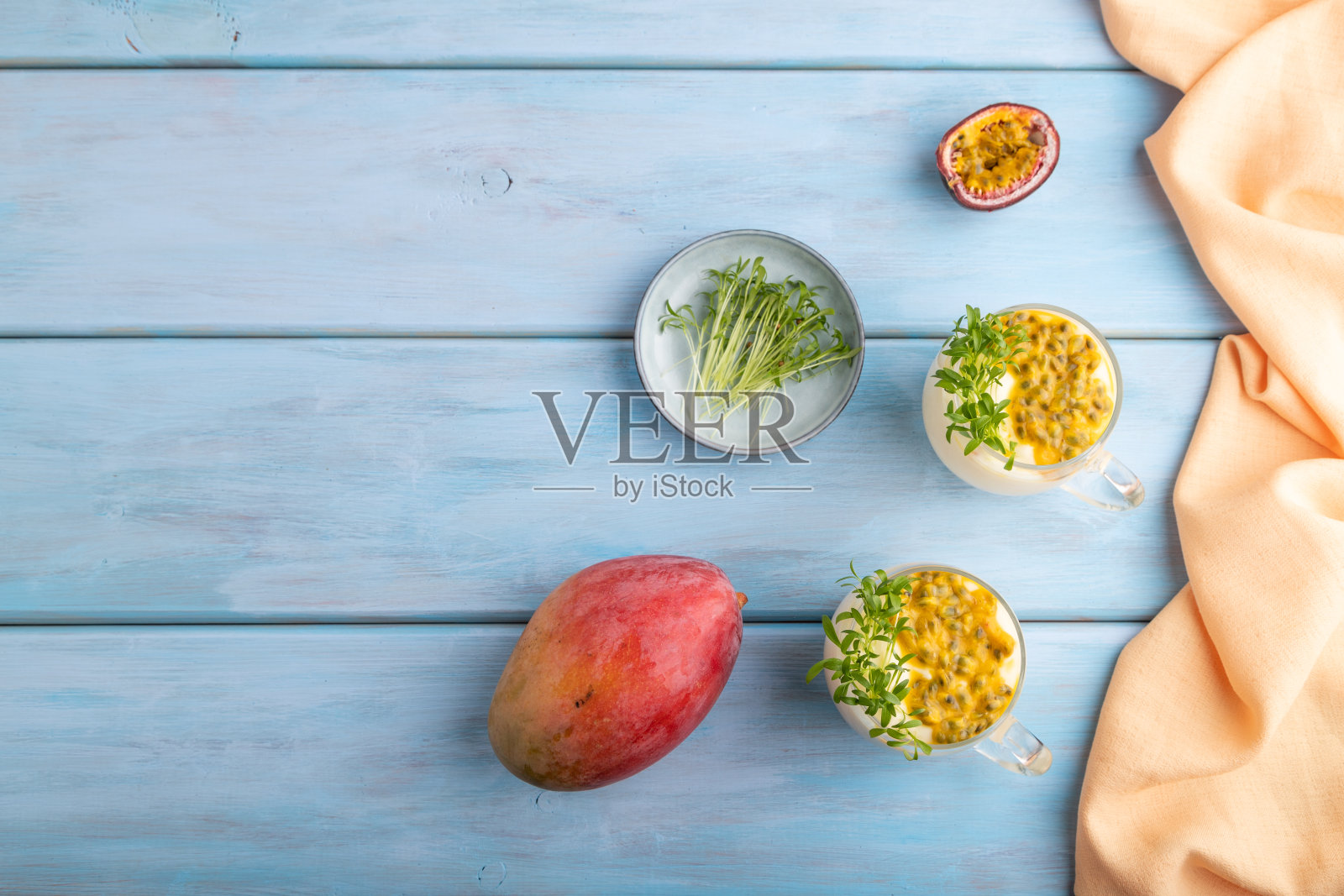 芒果酸奶配西番莲和香菜的微绿色玻璃杯。俯视图，复制空间。照片摄影图片