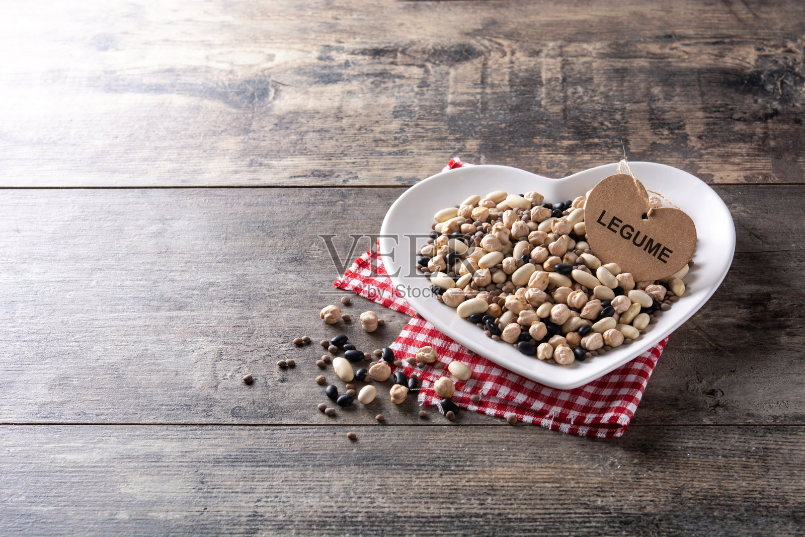 未煮的什锦豆类在心型盘照片摄影图片