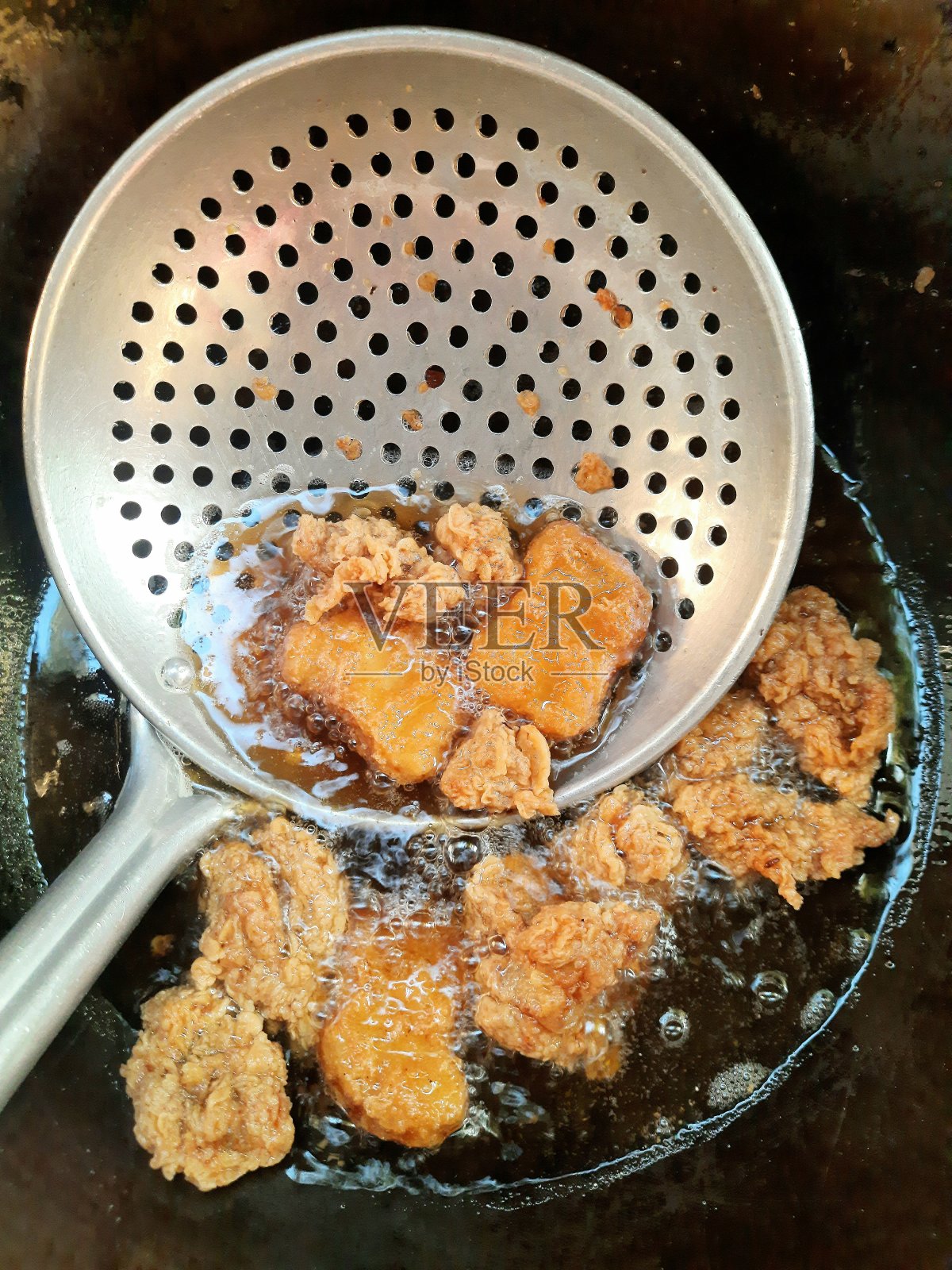 在煎锅中炸鸡块和爆米花。照片摄影图片