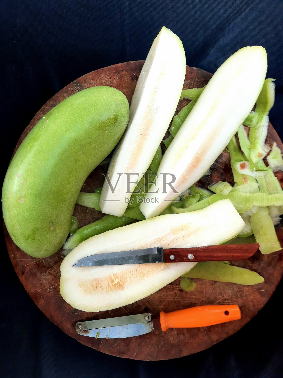 切菜板上的葫芦皮蔬菜-食物准备。照片摄影图片