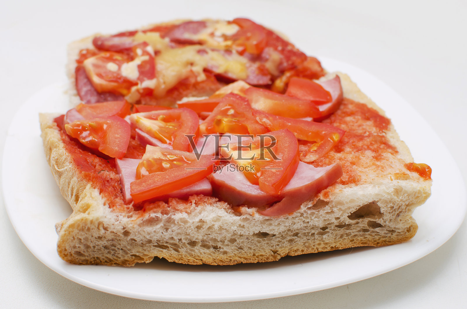 白面包三明治，香肠，西红柿和酱汁在白色的背景。照片摄影图片