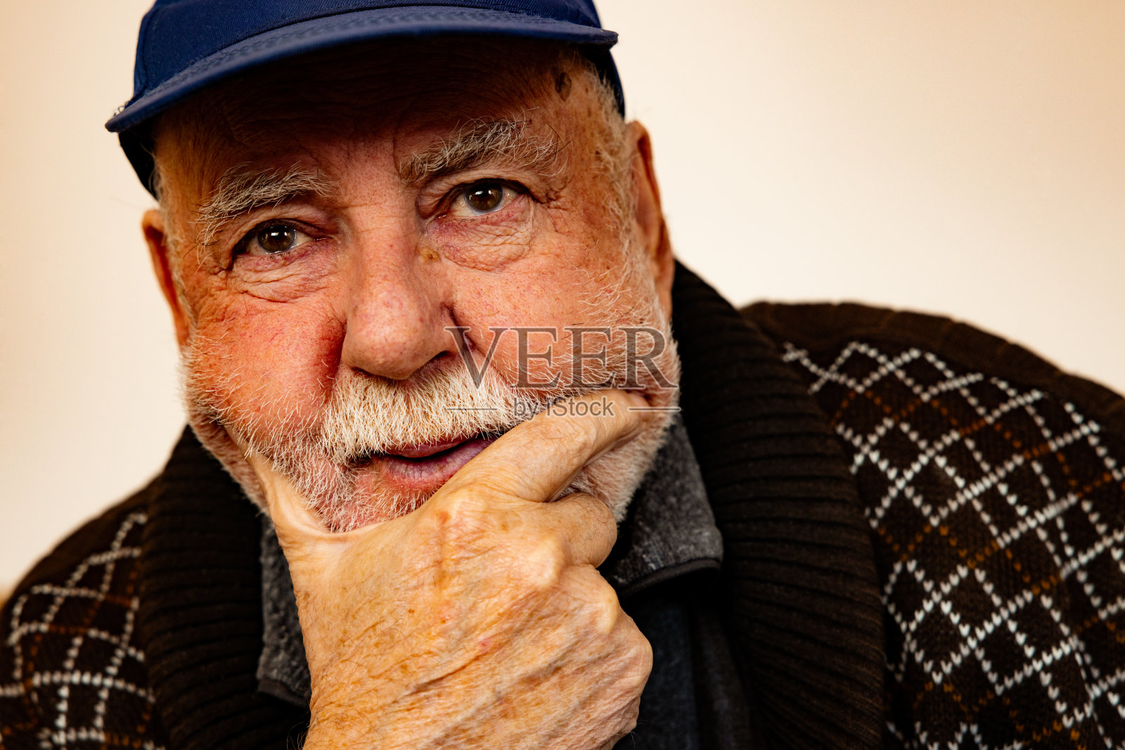 沉思的白人老人，一只手放在下巴上照片摄影图片