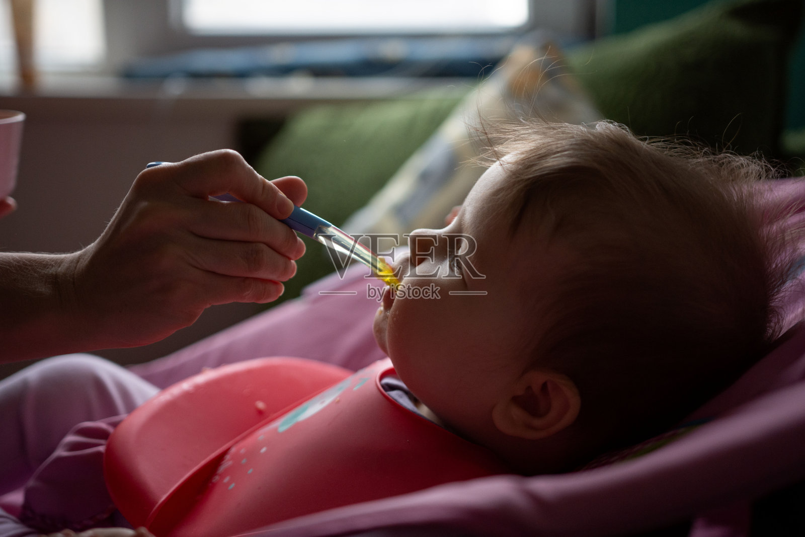 妈妈用勺子喂可爱的小女孩照片摄影图片