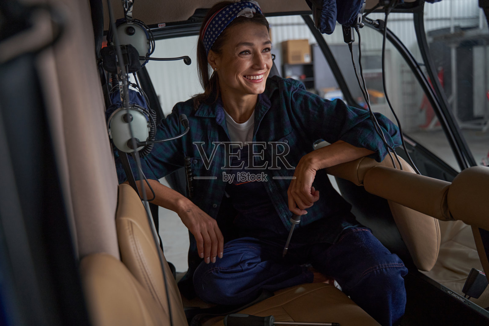 在机库螺旋桨飞机中，女机械师在相机前摆姿势照片摄影图片