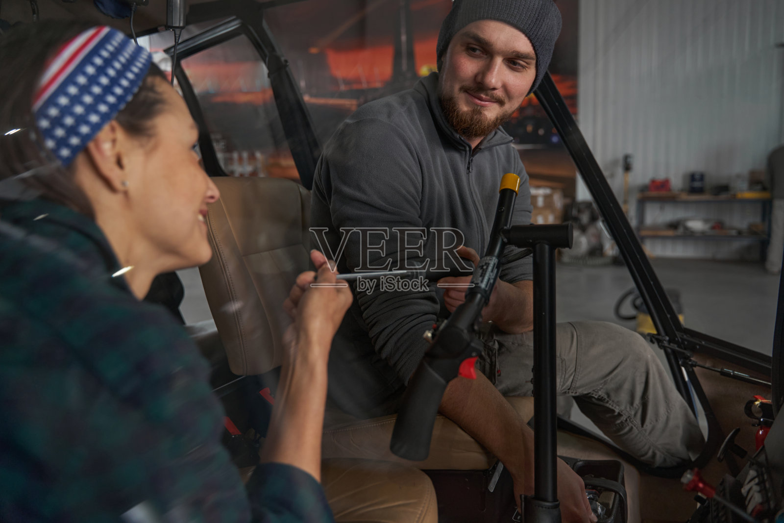 大胡子机械师看着机库里的女人照片摄影图片