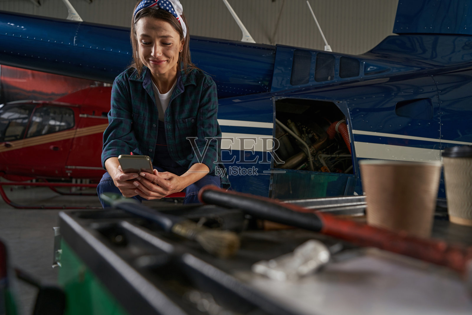 快乐优雅的女救援工程师在机库休息期间休息照片摄影图片