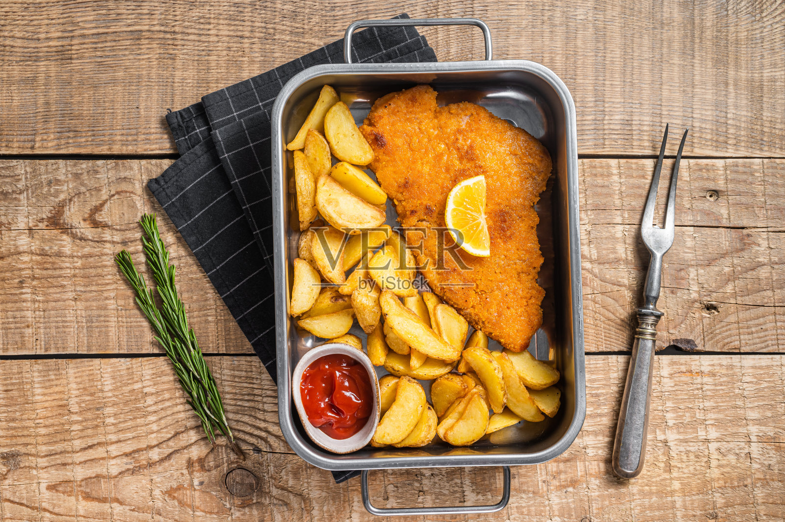 钢盘里的猪肉香肠炸肉排配土豆片和番茄酱。木制背景。俯视图照片摄影图片