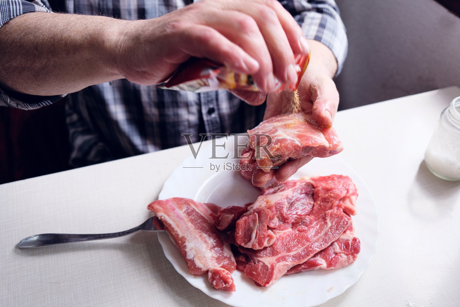 男子手调味生牛排骨照片摄影图片