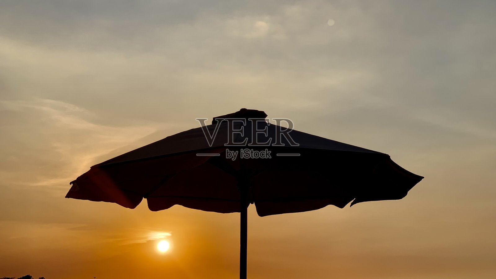 沙滩伞和日落美景照片摄影图片