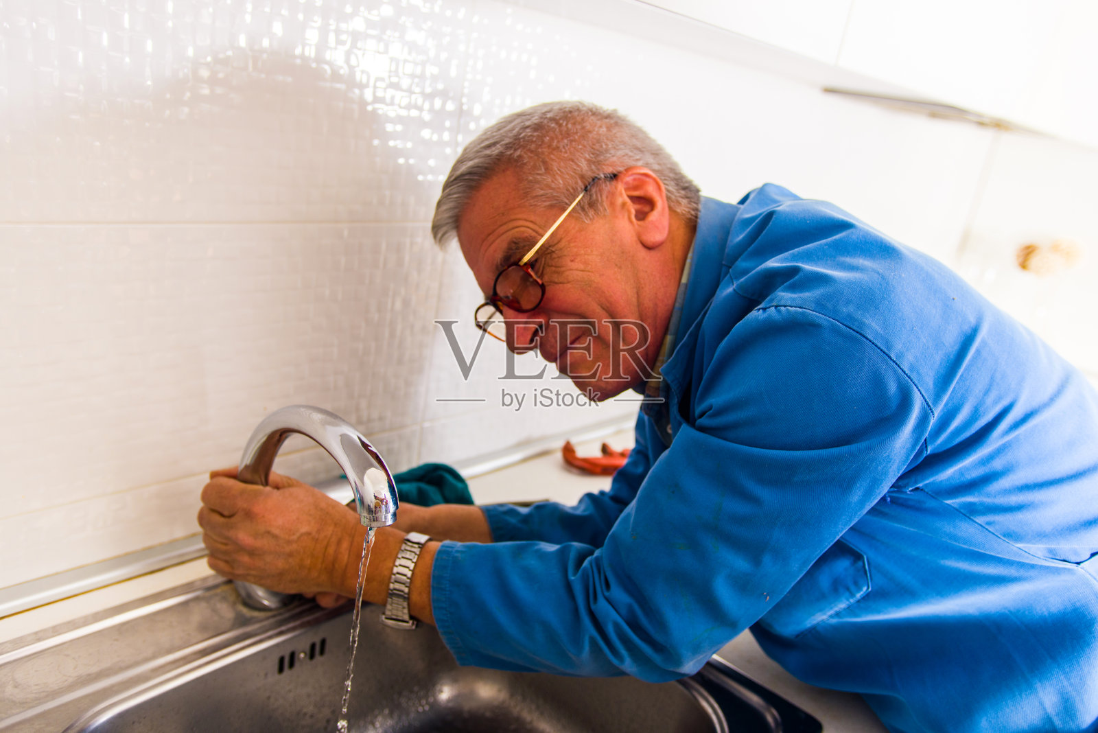 高级工人修理厨房水龙头照片摄影图片