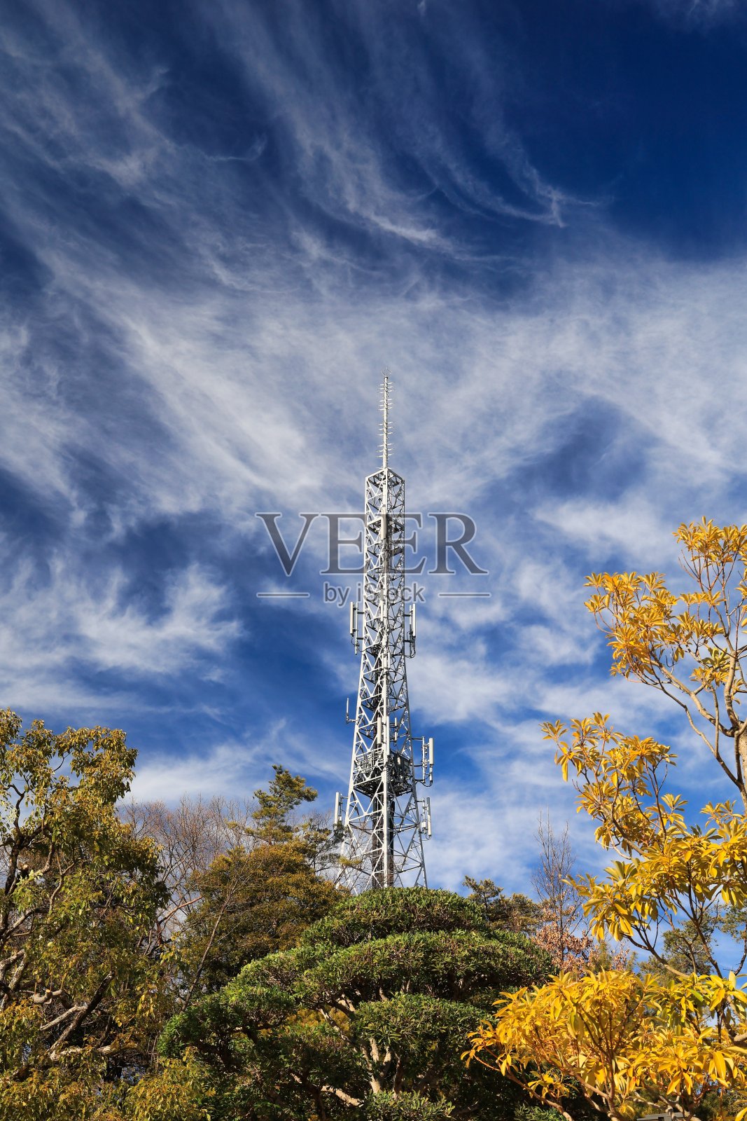 银色的无线电塔耸立在蓝色的秋天的天空照片摄影图片