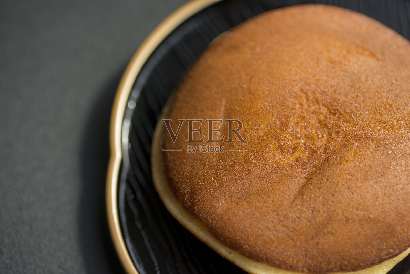 黑色盘子上的日式甜鱼烧。照片摄影图片