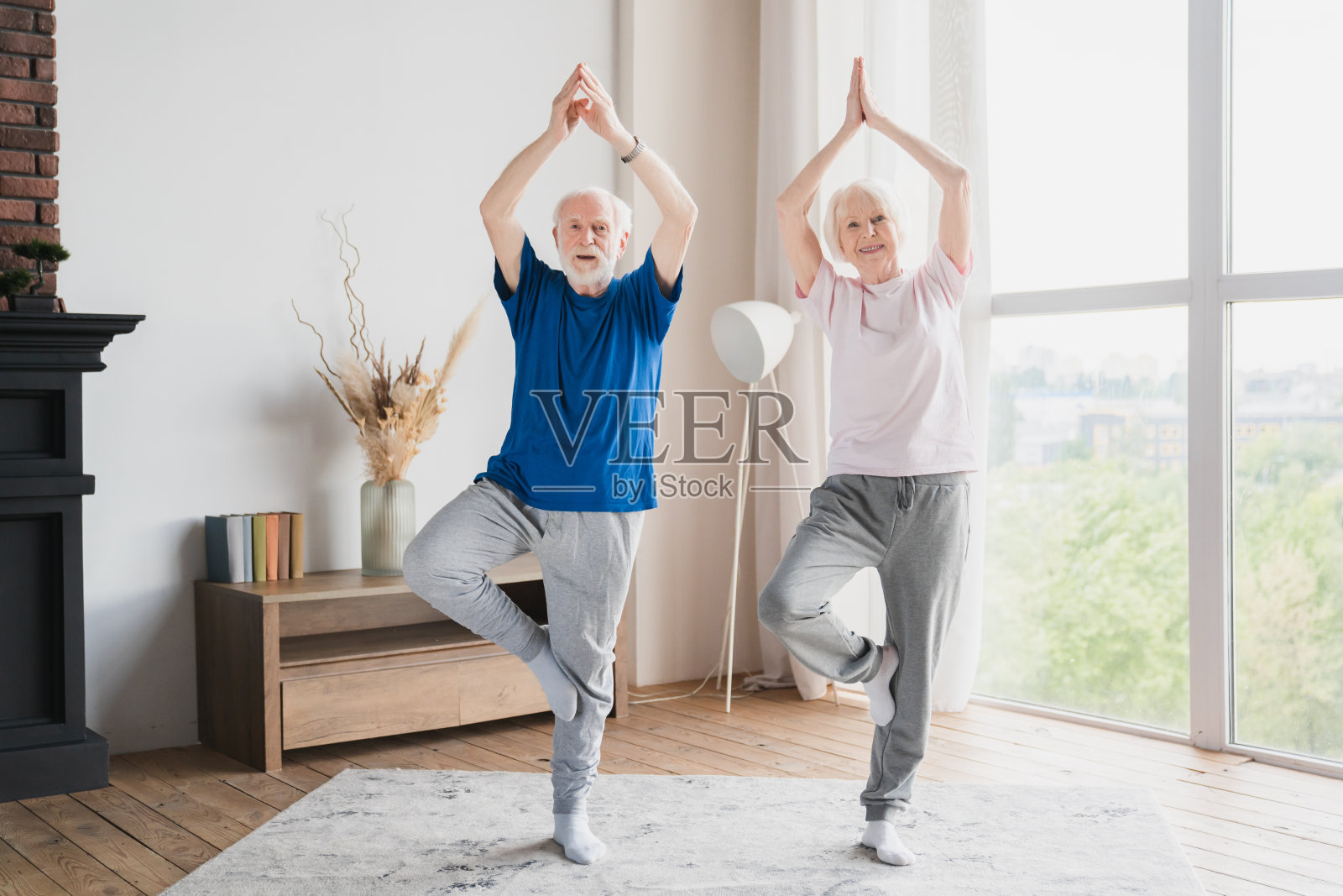 健身运动老年夫妇家庭配偶祖父母训练伸展运动在家做瑜伽练习一起禁闭保持单脚平衡。照片摄影图片