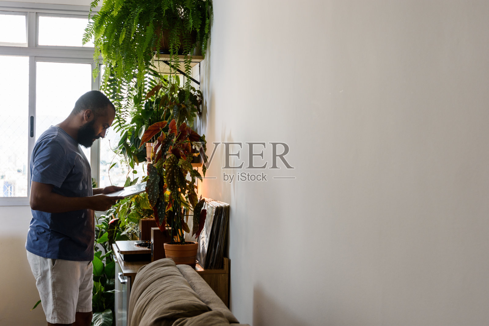 年轻的黑人在家里听黑胶音乐照片摄影图片