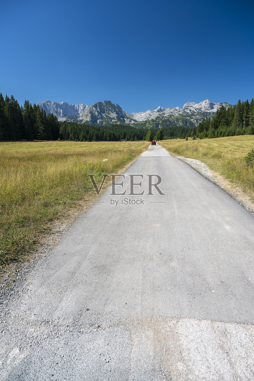 一辆红色的车朝山上开去照片摄影图片