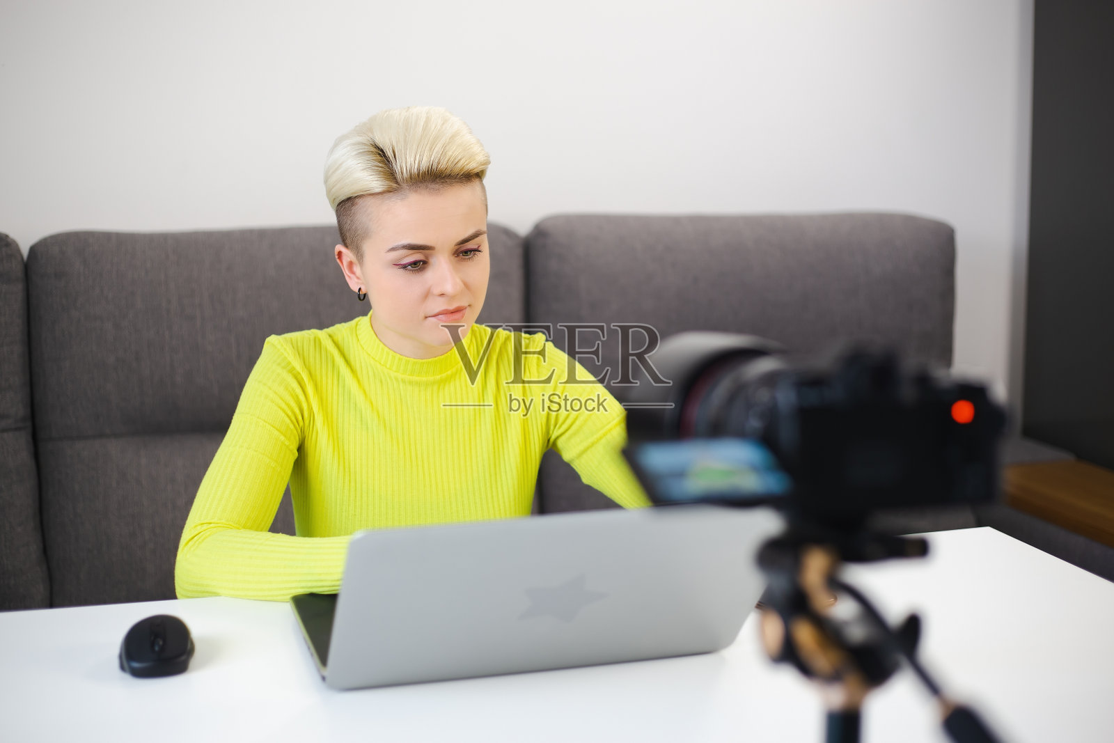 汤姆男孩女人在家里拍摄视频博客。企业家女商人用三脚架上的专业摄像机拍摄教育镜头。美丽的短发女性博客照片摄影图片