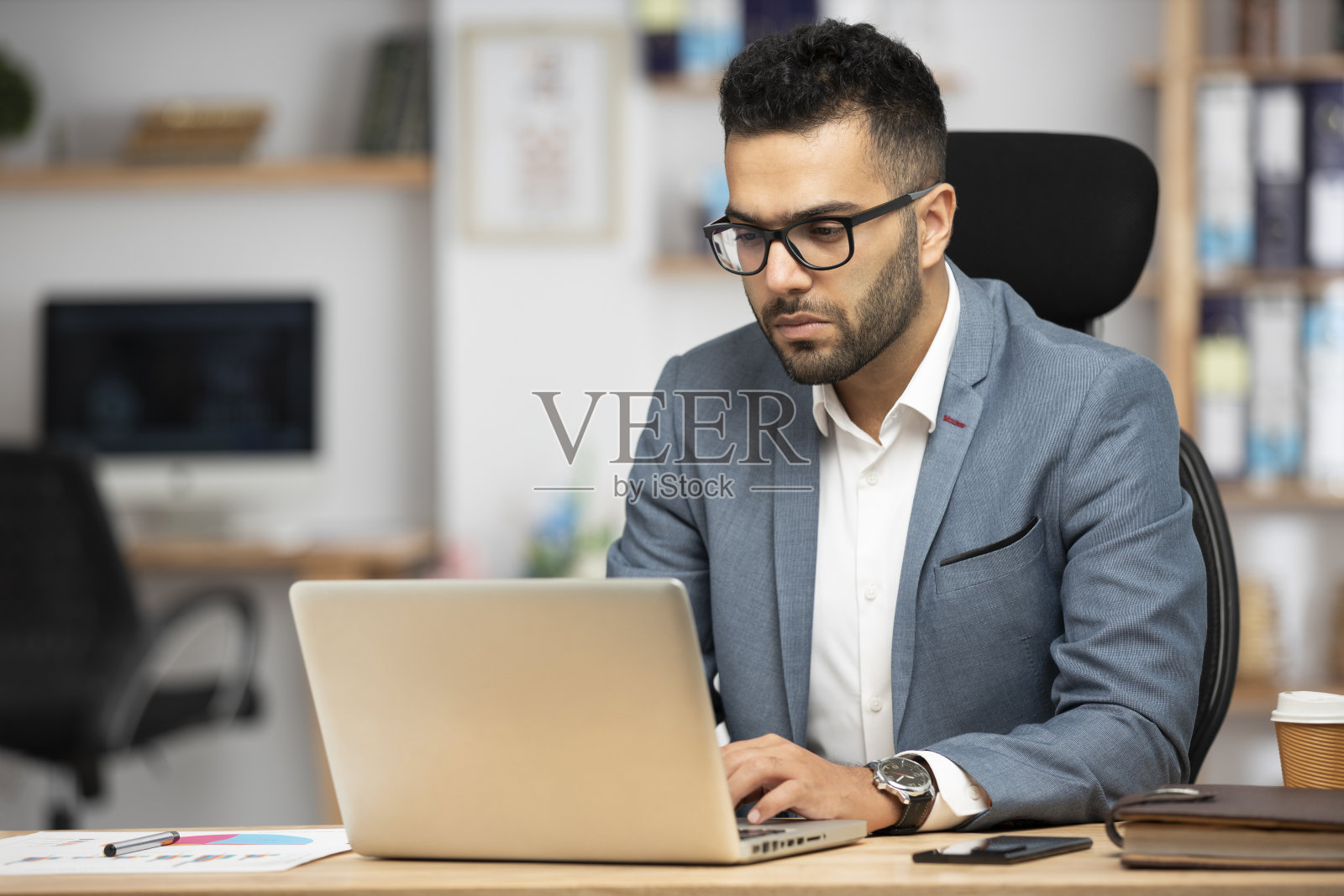 一个英俊的年轻商人在办公室工作的肖像照片摄影图片