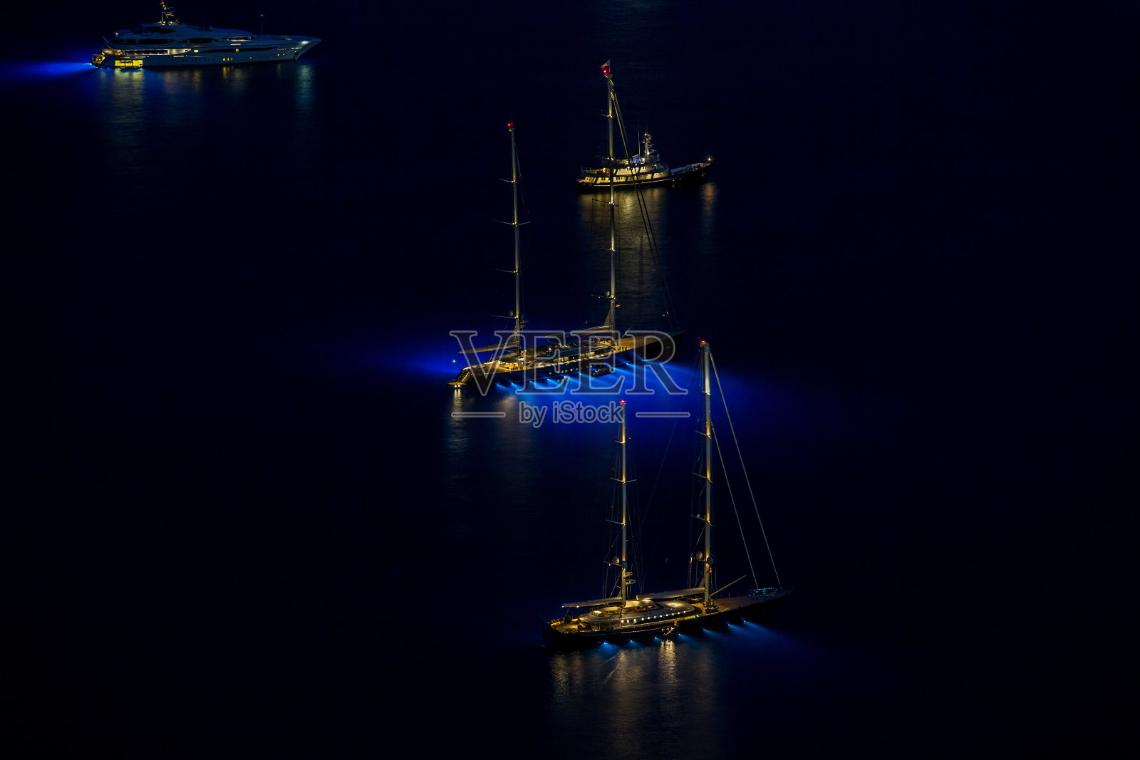 空中全景豪华游艇，夜间照明，长曝光，高桅杆，船停泊在海上照片摄影图片