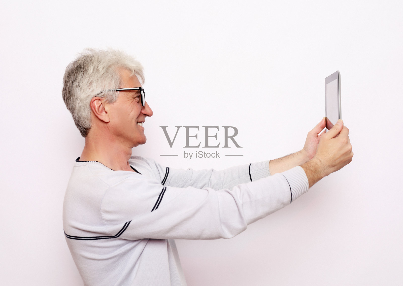 一位白发苍苍的老人用平板电脑与家人交流照片摄影图片